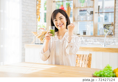 野菜ジュースを持ってガッツポーズする若い女性 野菜ジュースを持ってガッツポーズする若い女性 72427124