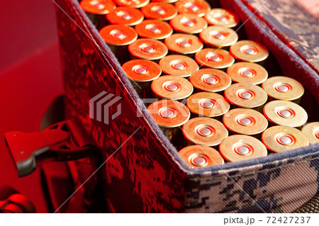 Shotgun cartridges in a cartridge bag in red light close up Shotgun cartridges in a cartridge bag in red light close up 72427237
