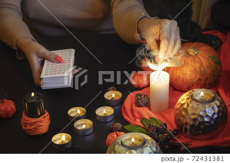 Blurred hand with matchstick, lighting a Candle. Halloween esoteric Blurred hand with matchstick, lighting a Candle. Halloween esoteric 72431381