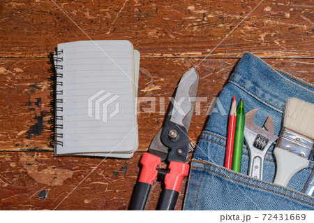DIY、木目の床に置かれたメモ帳とジーンズのポケットに入った工具 DIY、木目の床に置かれたメモ帳とジーンズのポケットに入った工具 72431669