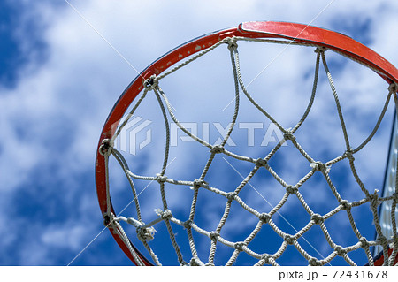青空を背景にオレンジのバスケットゴールの写真素材