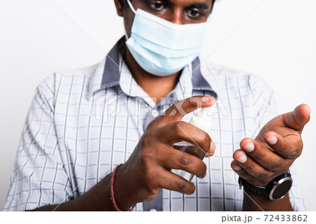 black man wearing protective face mask fear in eye holding show sanitizer spray black man wearing protective face mask fear in eye holding show sanitizer spray 72433862
