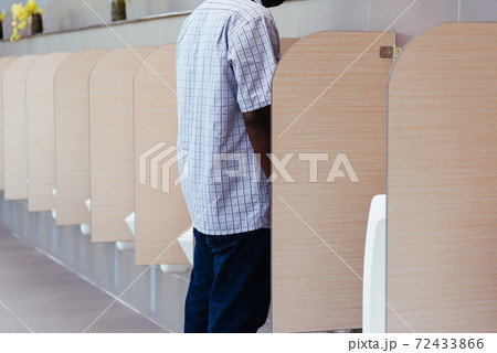 man peeing in male toilet urinals man peeing in male toilet urinals 72433866