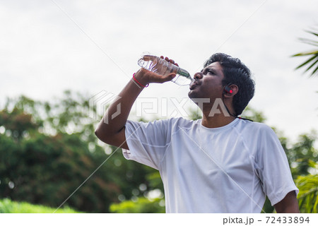 sport runner black man wear athlete headphones he drinking water from a bottle 72433894
