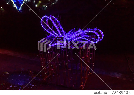 Illuminated Christmas gift box at night. Decoration for Christmas and New Years holidays in a city park Illuminated Christmas gift box at night. Decoration for Christmas and New Years holidays in a city park 72439482