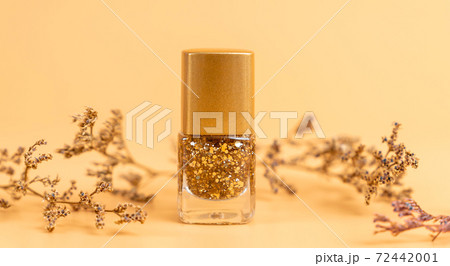 Nail polish of beautiful gold colors on orange background. Nail polish of beautiful gold colors on orange background. 72442001