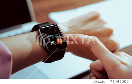 Close up of hand touching smartwatch with health app on the screen. 72442309