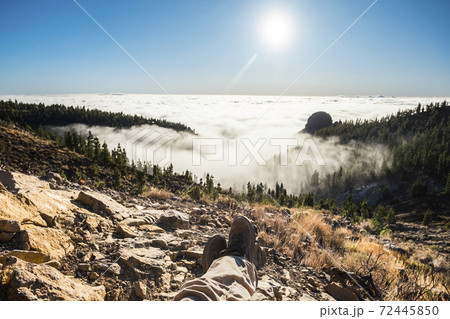 Man people point of view on legs an shoes with valley down there and beautiful view on clouds and forest - blue horizon sky in background - adventure travel concept Man people point of view on legs an shoes with valley down there and beautiful view on clouds and forest - blue horizon sky in background - adventure travel concept 72445850