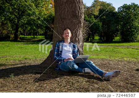 Guy working on laptop in the park 72446507