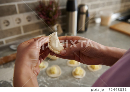 A woman making traditional dumplings ( vareniki or ravioli ) 72448031