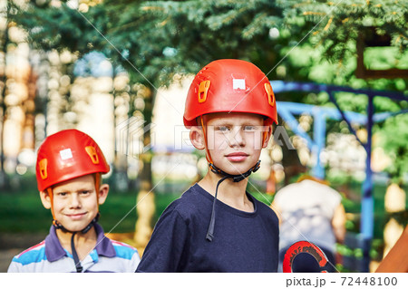 Two boys with climbing gear standing in rope park Two boys with climbing gear standing in rope park 72448100