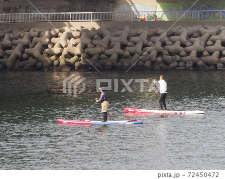 サップボードで河口を下って海に行くシニア夫婦 サップボードで河口を下って海に行くシニア夫婦 72450472