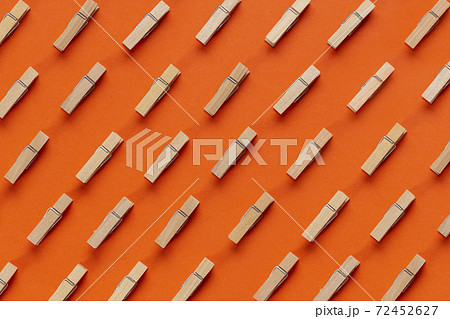 Many wooden clothespin on orange background. Many wooden clothespin on orange background. 72452627