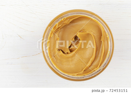 Jar of peanut butter on white wooden table. Space for text. 72453151