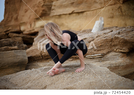 young beautiful woman meditates by the sea young beautiful woman meditates by the sea 72454420