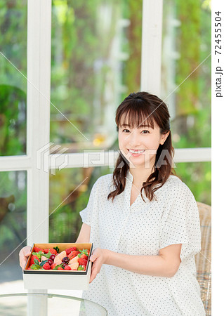 宝石箱のようなフルーツを持った女性 72455504
