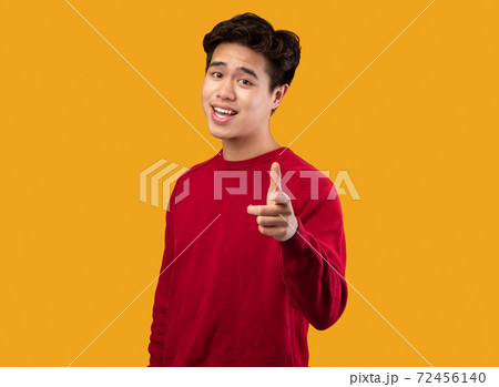 Smiling asian guy pointing finger at camera at studio Smiling asian guy pointing finger at camera at studio 72456140