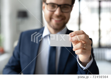 Close up confident businessman showing empty business card at camera 72456564