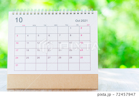 Calendar desk 2021 October month for organizer to plan and reminder on wooden table on nature background. 72457947