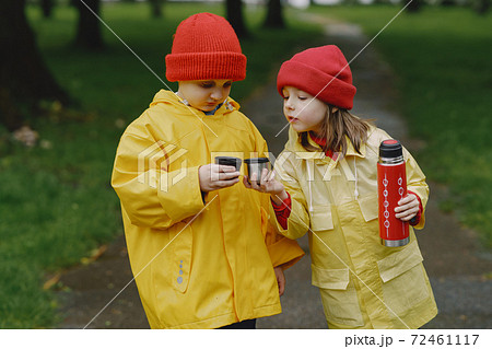 Funny kids in rain boots playing in a rainy park Funny kids in rain boots playing in a rainy park 72461117
