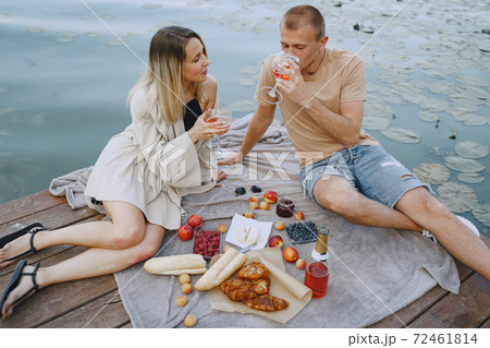 People sitting by the water with picnic set 72461814