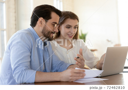Smiling colleagues cooperate on laptop in office 72462810