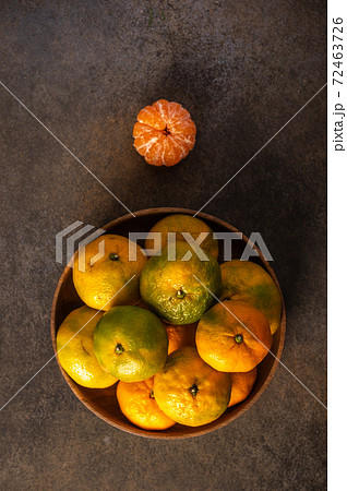 Tangerines or mandarines in bamboo bowl on wooden background Tangerines or mandarines in bamboo bowl on wooden background 72463726