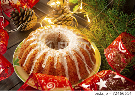 Traditional homemade christmas cake holiday dessert with new year tree decorations frame on vintage dark wooden table. Rustic style. 72466614
