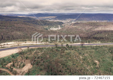 Aerial photograph of a highway and a forest after bushfires in regional Australia 72467155