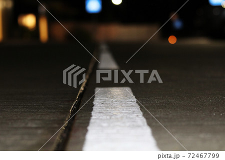 Road markings on a wet concrete roadway 72467799