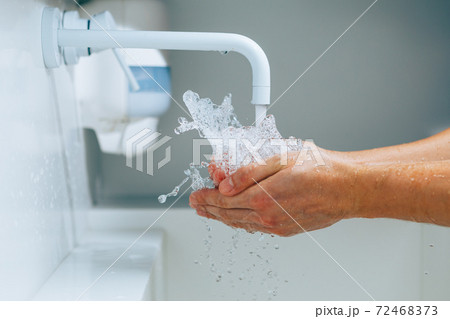 hands under the faucet with splashing water hands under the faucet with splashing water 72468373