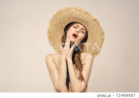 Romantic woman in a hat and dress on a light background gestures with her hands portrait fun emotions cropped view Romantic woman in a hat and dress on a light background gestures with her hands portrait fun emotions cropped view 72469087