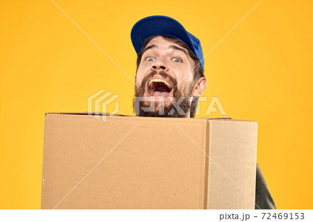 A man in a working form a box with loading tools yellow background A man in a working form a box with loading tools yellow background 72469153