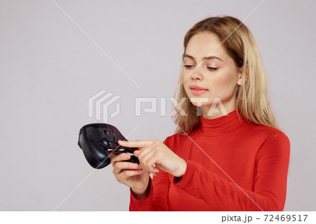 Woman with gamepad in hands playing games emotions lifestyle leisure red shirt light background Woman with gamepad in hands playing games emotions lifestyle leisure red shirt light background 72469517