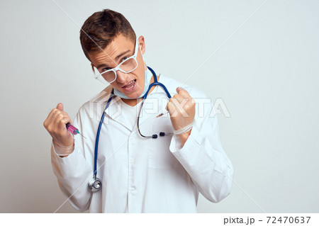 doctor in a medical gown with a stethoscope and glasses on a light background cropped view portrait doctor in a medical gown with a stethoscope and glasses on a light background cropped view portrait 72470637
