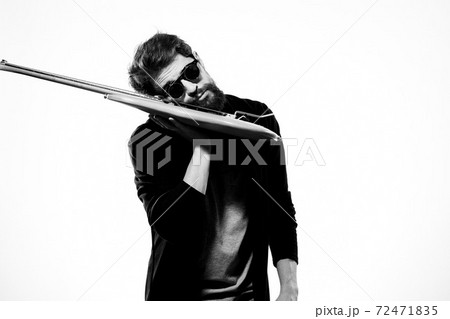 A man holds a guitar in his hands black leather jacket dark glasses music performance light background 72471835