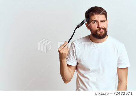 man with cooking shovel and white t-shirt close-up cropped view emotion gesturing with hand 72472971