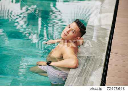 Man relaxing in swimming pool 72473648