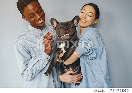 International couple on a blue background with a dog International couple on a blue background with a dog 72475849