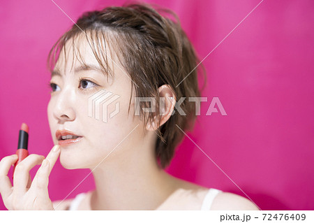 口紅を塗るアジア人の若い女性 口紅を塗るアジア人の若い女性 72476409