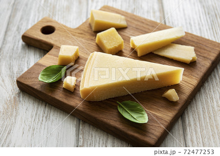 Piece of parmesan cheese on a wooden board 72477253