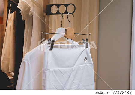White shirt and skirt hanging in the closet. White shirt and skirt hanging in the closet. 72478435