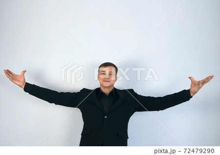 Showman magician presents his show, spreading his hands up to the sides. 72479290