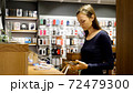 Young woman chooses a new smartphone in an electronics store. 72479300