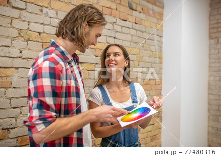 Young couple looking at color palette and choosing the wall color 72480316
