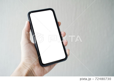 Man hand holding smartphone with blank screen on gray background, closeup of hand. Space for text. Man hand holding smartphone with blank screen on gray background, closeup of hand. Space for text. 72480730
