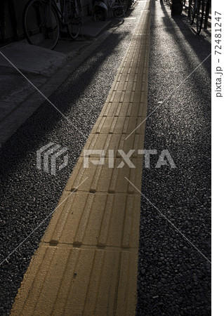 黄色い視覚障碍者用線状ブロックのある道の写真素材