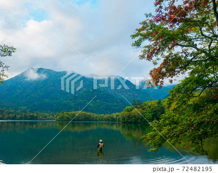 紅葉の始まった湖のほとりで釣りを楽しむ人 湯ノ湖 奥日光 栃木県 の写真素材