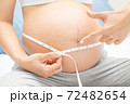 Pregnant woman measures her stomach 72482654