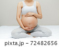 Pregnant woman touching her big belly. Close up. Motherhood, pregnancy, people and expectation concept. Pregnant woman expecting bab 72482656